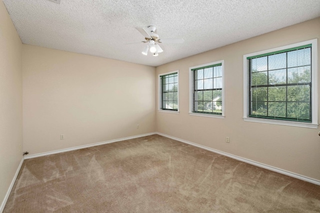 unfurnished room featuring a textured ceiling, ceiling fan, and light colored carpet