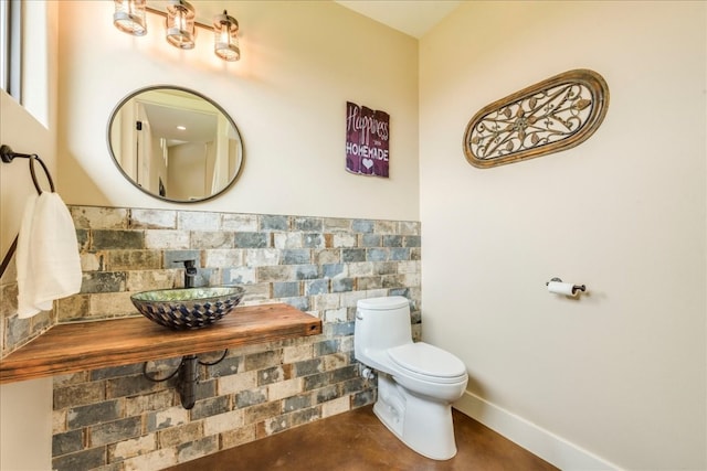 bathroom with sink, backsplash, and toilet