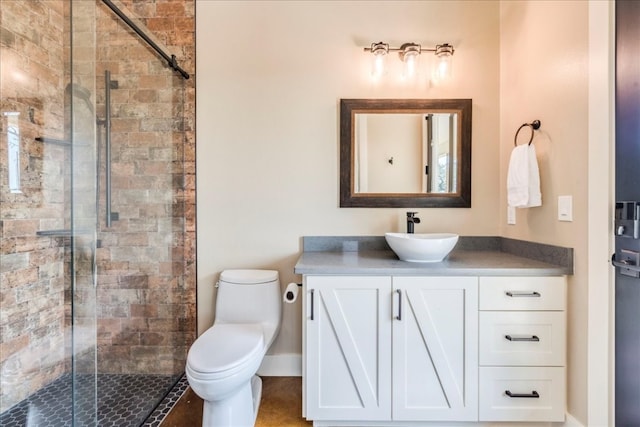 bathroom with toilet, a shower with shower door, and vanity