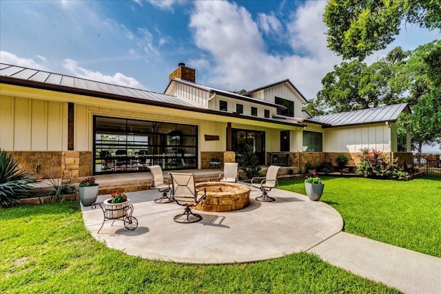 rear view of house with an outdoor fire pit, a patio area, and a yard