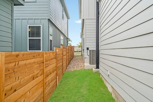 view of side of home with a yard and central air condition unit