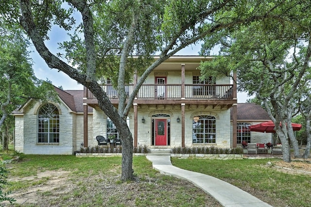 view of front of home featuring a front yard and a balcony