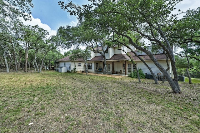 view of front of house with central AC and a front lawn