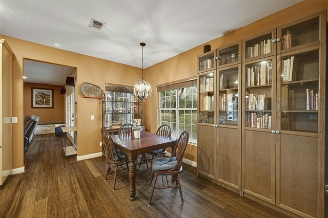 dining room featuring dark hardwood / wood-style flooring and an inviting chandelier