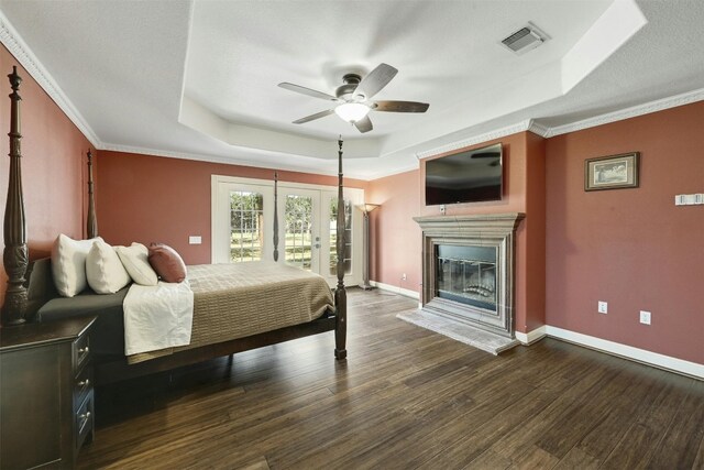 bedroom featuring ceiling fan, dark hardwood / wood-style floors, a raised ceiling, and crown molding