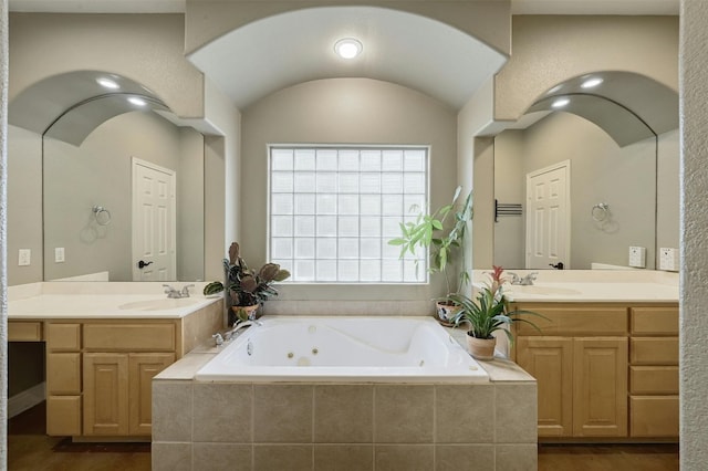 bathroom with vanity and a relaxing tiled tub