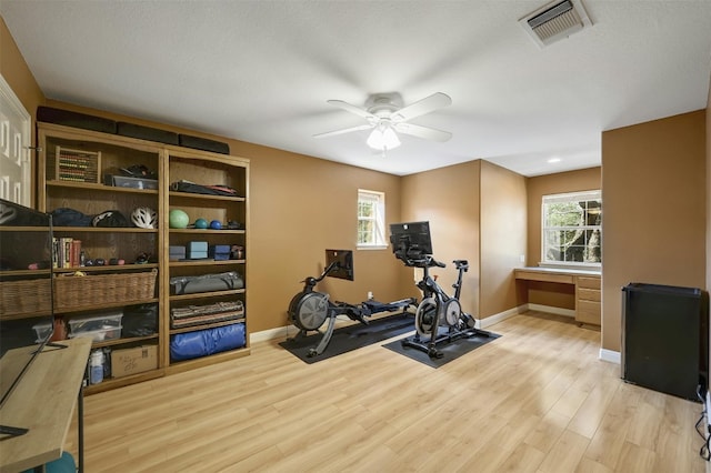 workout room featuring ceiling fan and light wood-type flooring