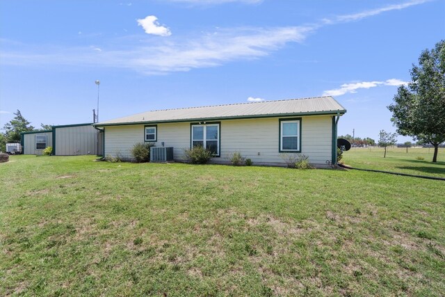 rear view of house featuring a lawn and cooling unit