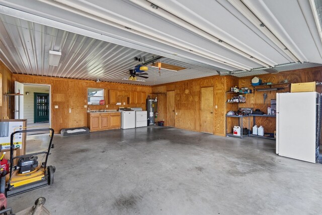 garage with water heater, wooden walls, white fridge, a garage door opener, and ceiling fan