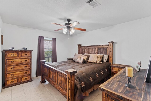 bedroom featuring a textured ceiling, ceiling fan, and light tile patterned floors