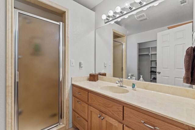 bathroom featuring vanity and a shower with shower door