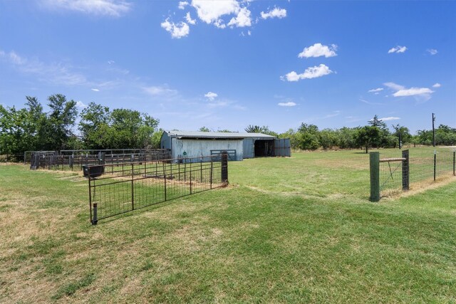 view of yard featuring an outdoor structure and a rural view