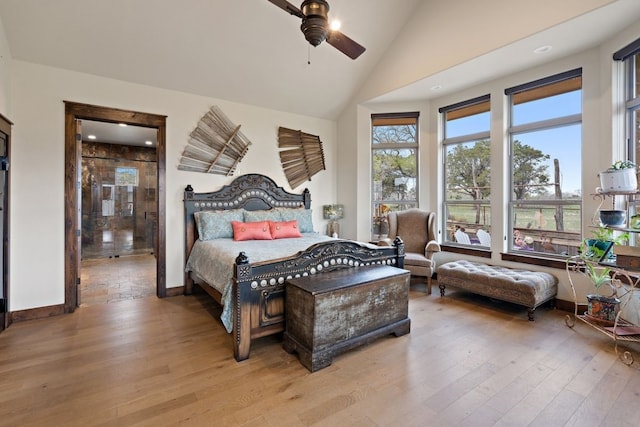 bedroom featuring ceiling fan, light hardwood / wood-style flooring, and high vaulted ceiling