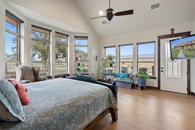 bedroom featuring multiple windows, light hardwood / wood-style flooring, and high vaulted ceiling