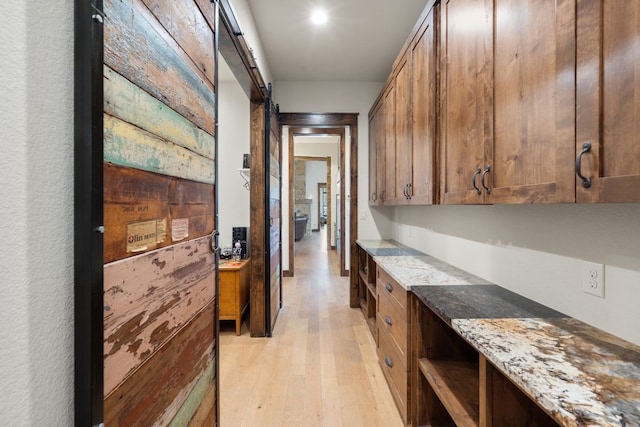 interior space with light wood-type flooring and a barn door