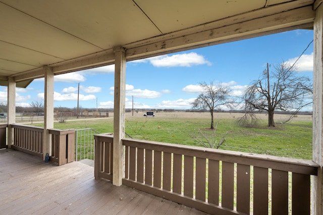 wooden deck featuring a rural view and a lawn