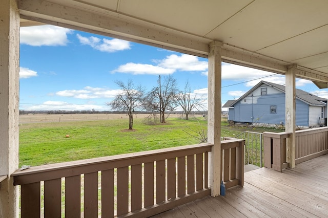 wooden deck featuring a lawn and a rural view