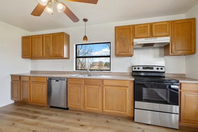 kitchen featuring ceiling fan, appliances with stainless steel finishes, sink, light wood-type flooring, and pendant lighting