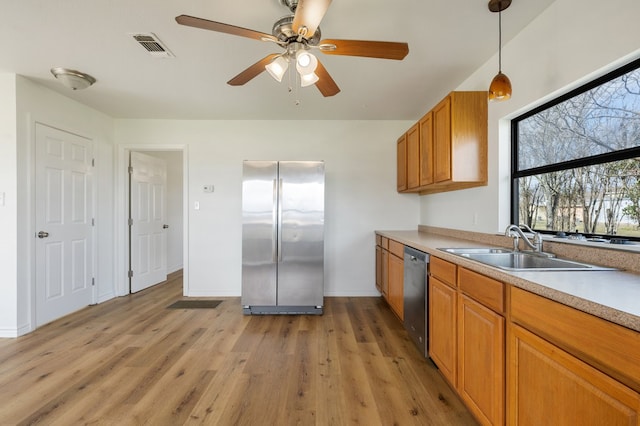 kitchen with light hardwood / wood-style floors, hanging light fixtures, stainless steel appliances, and ceiling fan