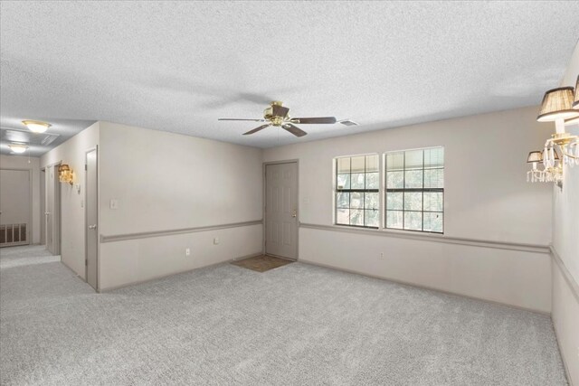 carpeted spare room featuring ceiling fan and a textured ceiling