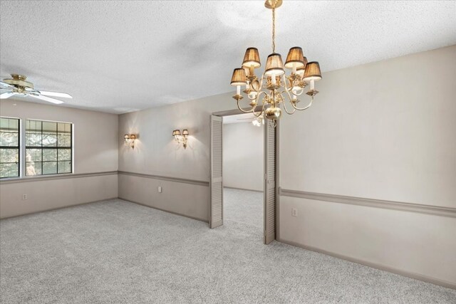 unfurnished room featuring a textured ceiling, ceiling fan with notable chandelier, and light colored carpet