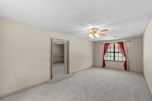 carpeted empty room with ceiling fan and a textured ceiling