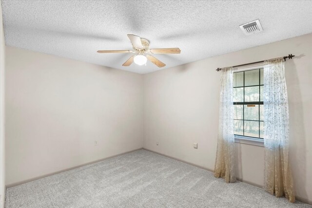 carpeted spare room with ceiling fan and a textured ceiling