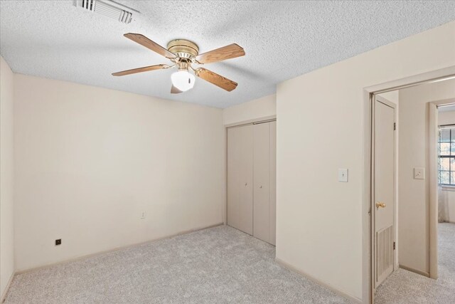 carpeted empty room featuring a textured ceiling and ceiling fan