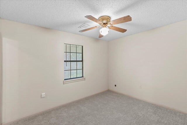 empty room featuring ceiling fan, carpet floors, and a textured ceiling