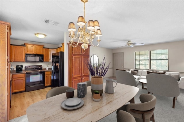 carpeted dining room with ceiling fan with notable chandelier