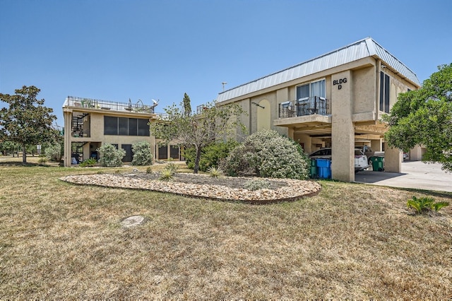 back of house with a balcony and a lawn