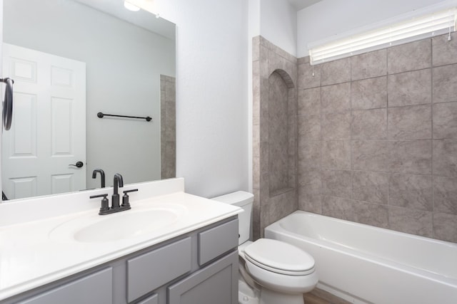 full bathroom featuring toilet, tiled shower / bath combo, and vanity with extensive cabinet space