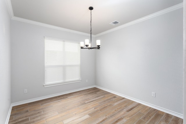 spare room with light hardwood / wood-style floors, ornamental molding, and a chandelier