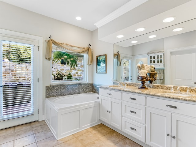 bathroom with a garden tub, tile patterned flooring, recessed lighting, a sink, and double vanity