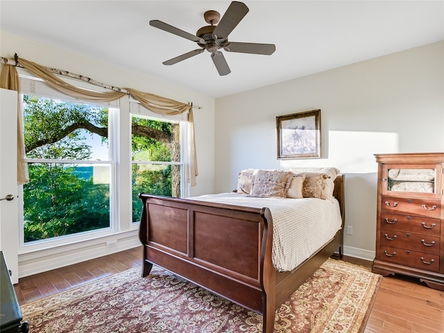 bedroom with ceiling fan, baseboards, and wood finished floors