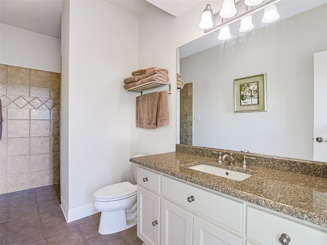 bathroom featuring toilet, tile patterned flooring, tiled shower, and vanity