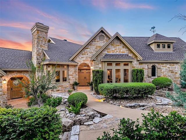 view of front of house featuring french doors and roof with shingles