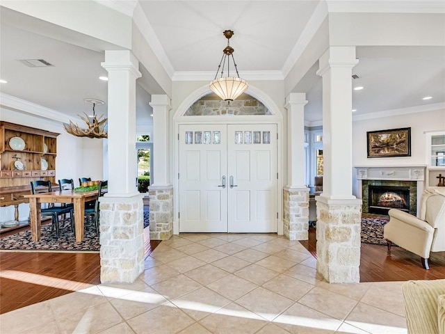 entrance foyer featuring ornamental molding and decorative columns