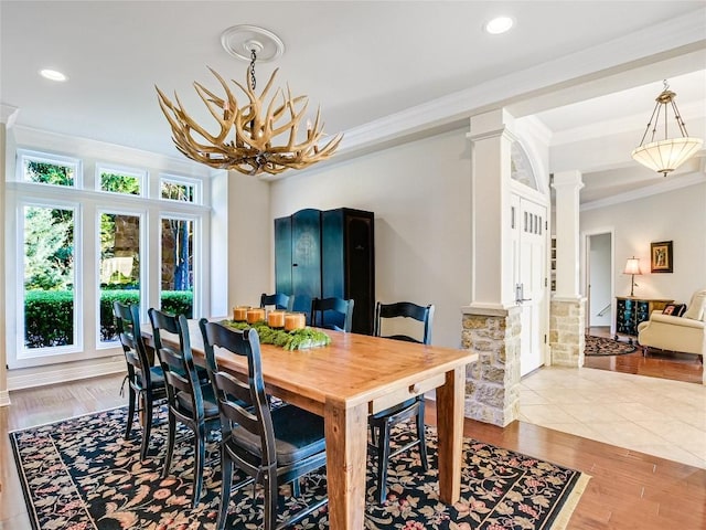 dining room featuring decorative columns, ornamental molding, light wood-type flooring, a chandelier, and recessed lighting