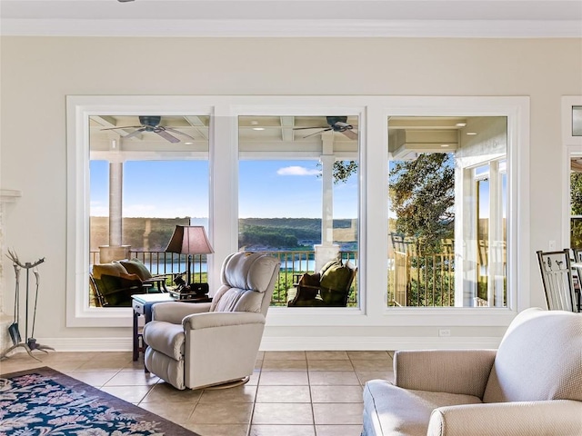 living area featuring ceiling fan, ornamental molding, and light tile patterned flooring