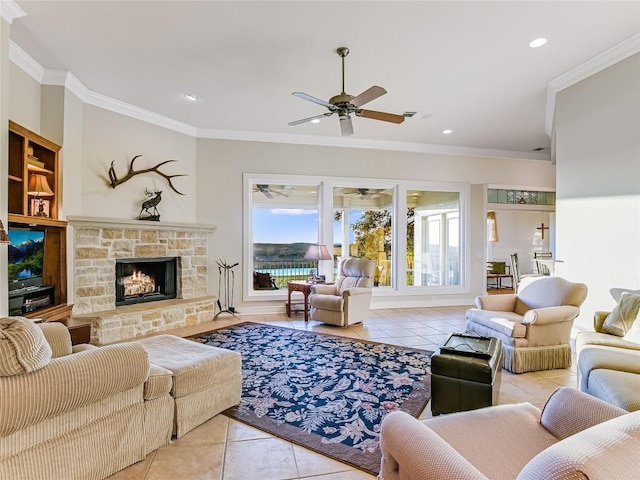 living room featuring light tile patterned floors, ceiling fan, a stone fireplace, recessed lighting, and crown molding