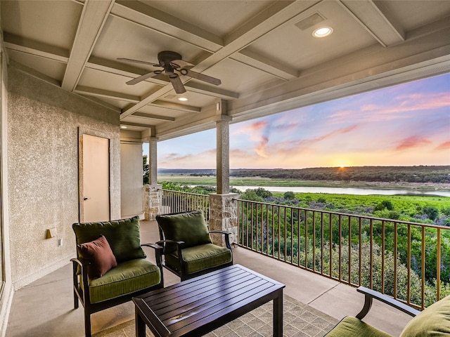 balcony with a water view and ceiling fan