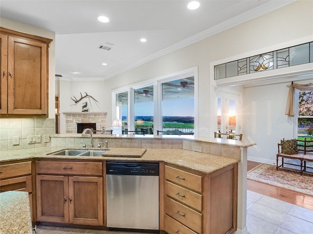 kitchen featuring a peninsula, a sink, visible vents, ornamental molding, and dishwasher