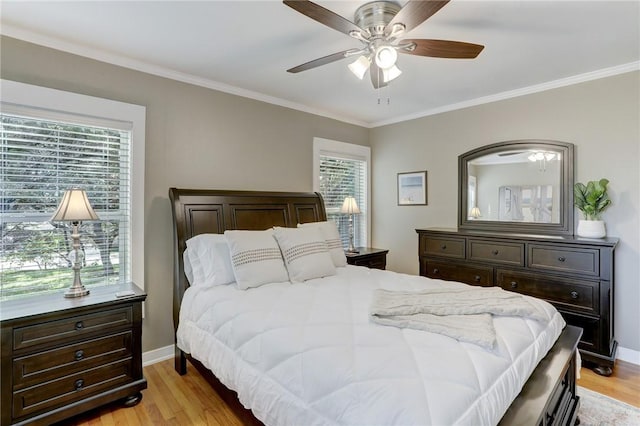 bedroom featuring light wood-style floors, multiple windows, and crown molding