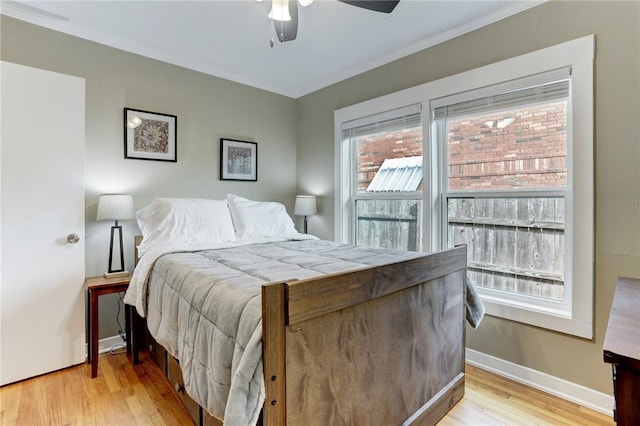 bedroom featuring light wood-style floors, baseboards, and a ceiling fan