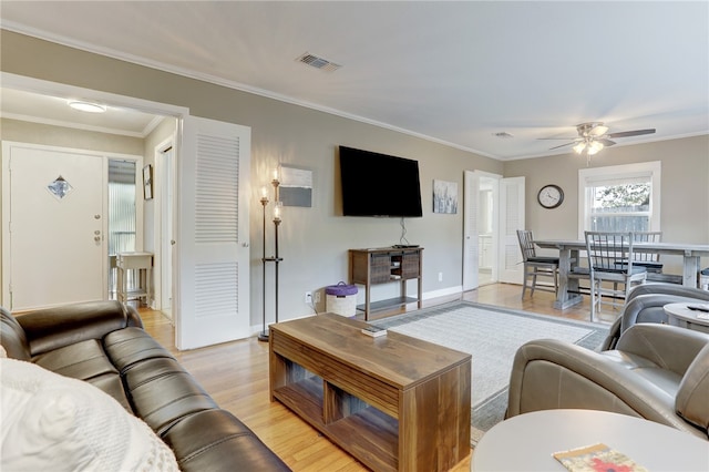 living room with light hardwood / wood-style floors, crown molding, and ceiling fan