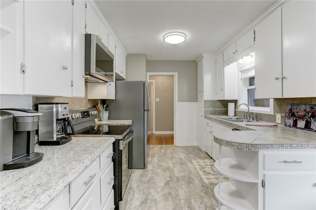 kitchen with sink, white cabinetry, decorative backsplash, and stainless steel appliances