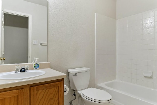 full bath with toilet, a textured wall, shower / washtub combination, and vanity