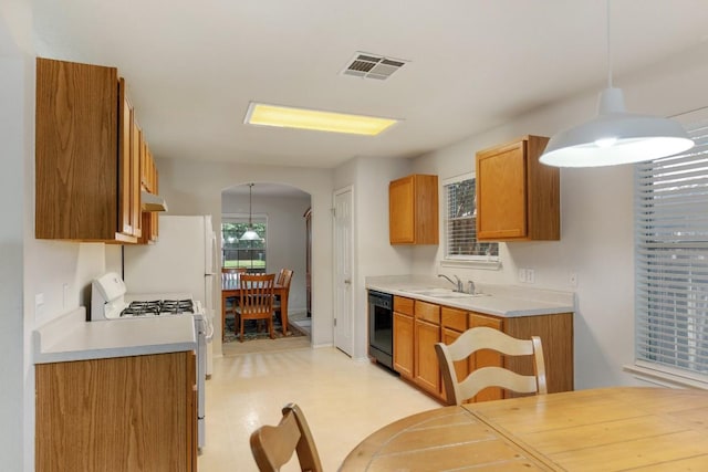 kitchen featuring visible vents, brown cabinetry, arched walkways, dishwasher, and range with gas cooktop