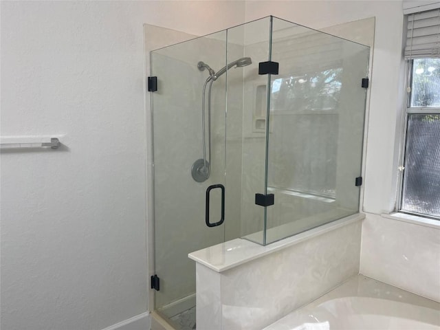 bathroom featuring a garden tub and a shower stall